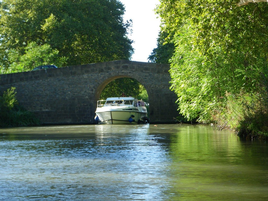 Boat passing under bridge