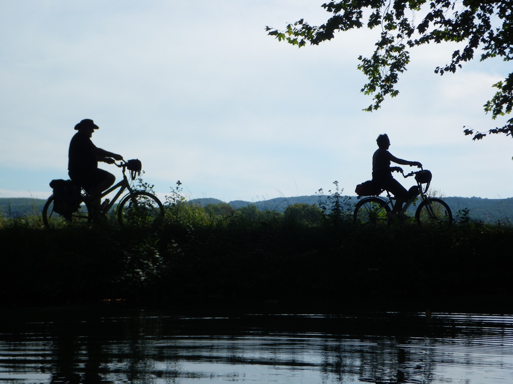 Cyclists silhouetted on canal bank